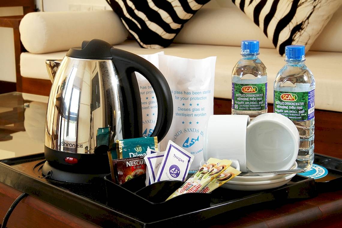 Kaffeeservice auf einem Tisch im Goldi Sands Hotel mit Wasserkocher, Tassen und verschiedenen Kaffeesorten.