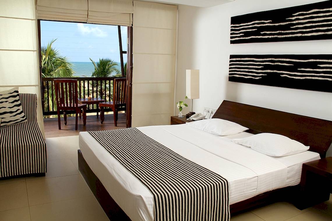 Hotelzimmer im Goldi Sands Hotel mit Blick auf einen Balkon und das Meer.