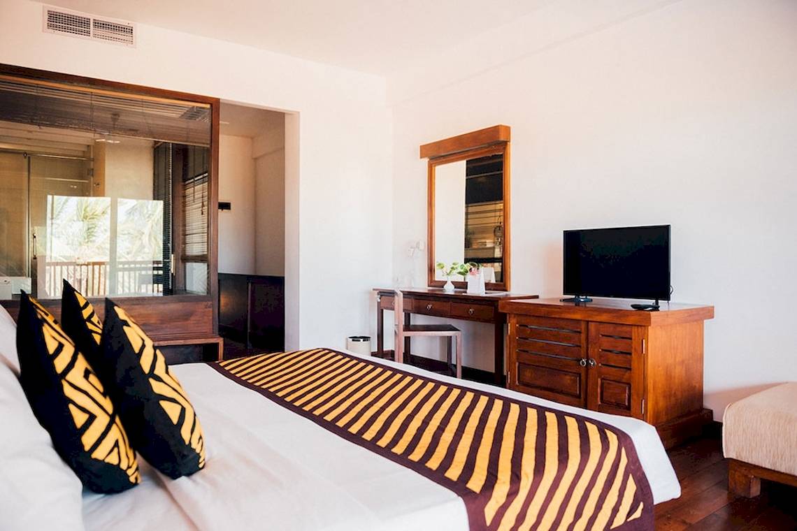 Hotelzimmer von Goldi Sands mit Bett, Fernseher und Schreibtisch