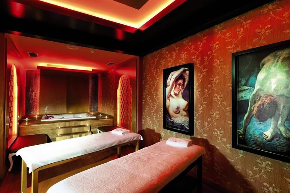 Spa-Behandlungsraum im Adalya Bliss Hotel mit zwei Massagetischen und kunstvollen Wandmalereien.