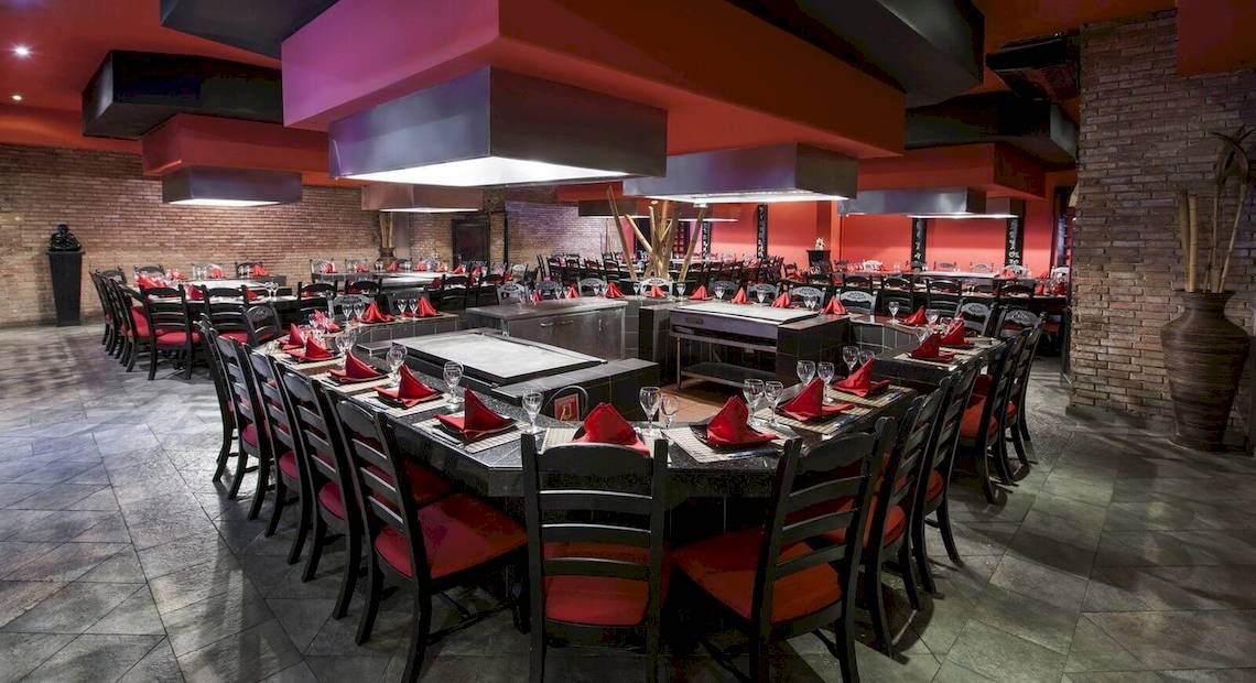 Innenansicht des Restaurants im Occidental Caribe Hotel mit vielen runden Tischen und roten Stühlen.
