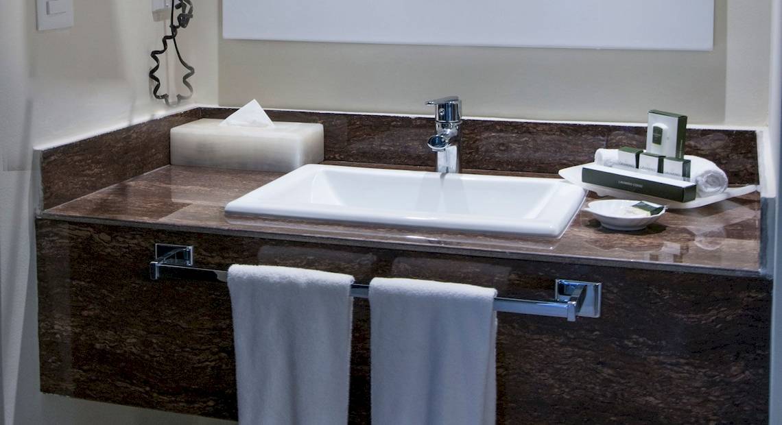 Badezimmer im Hotel Allegro Playacar mit Waschbecken, Handtüchern und Toilettenartikeln.