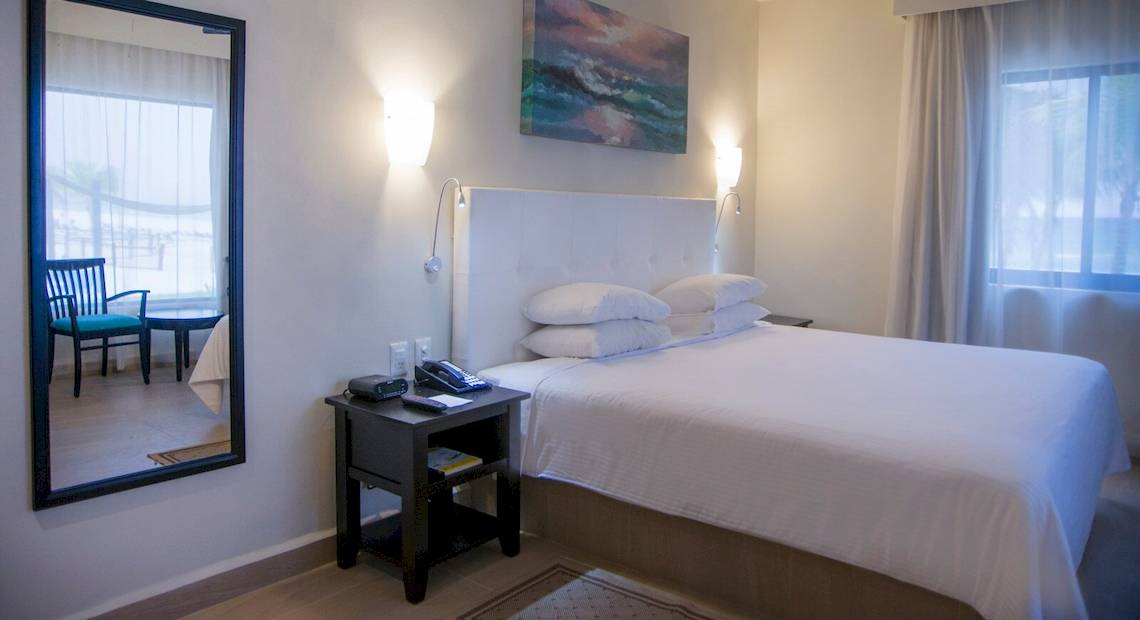 Hotelzimmer im Allegro Playacar mit einem Bett, Spiegel und Nachttisch.