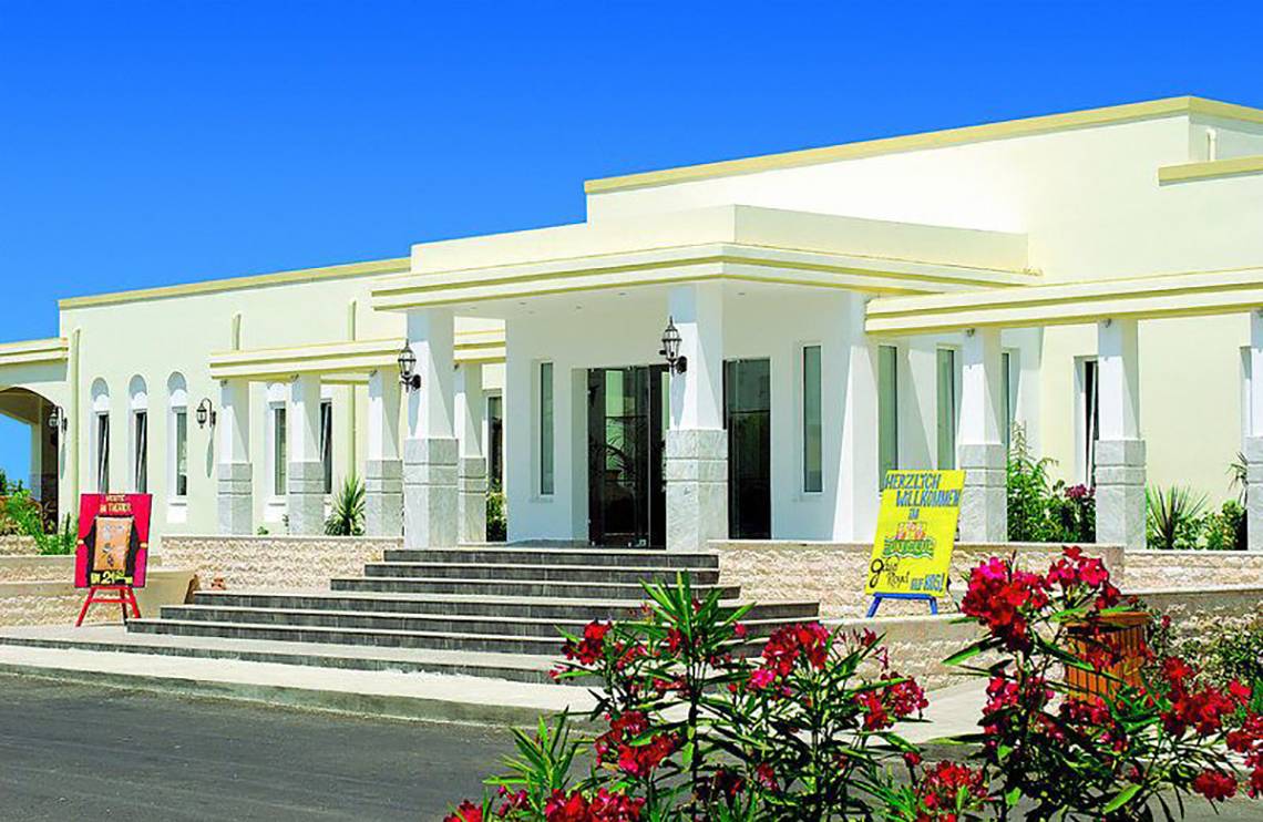 Außenansicht des Gaia Royal Hotels mit Blumen und Treppen davor.