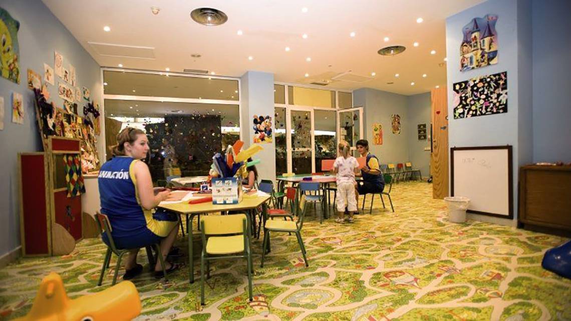 Kinderbetreuung im Hotel Maspalomas Princess mit einer Frau und Kindern an einem Tisch.