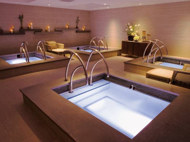 Whirlpools im Spa-Bereich des Mirage Hotel & Casino mit beleuchteten Innenräumen und Möbeln.