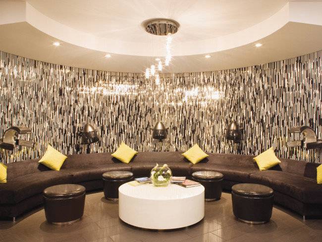 Loungebereich im Mirage Hotel & Casino mit L-förmiger Couch, gelben Kissen und zentralem Tisch.