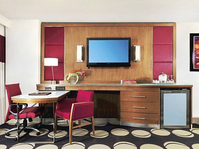 Arbeitsbereich im Mirage Hotel & Casino Zimmer mit Schreibtisch, Stühlen und Fernseher.