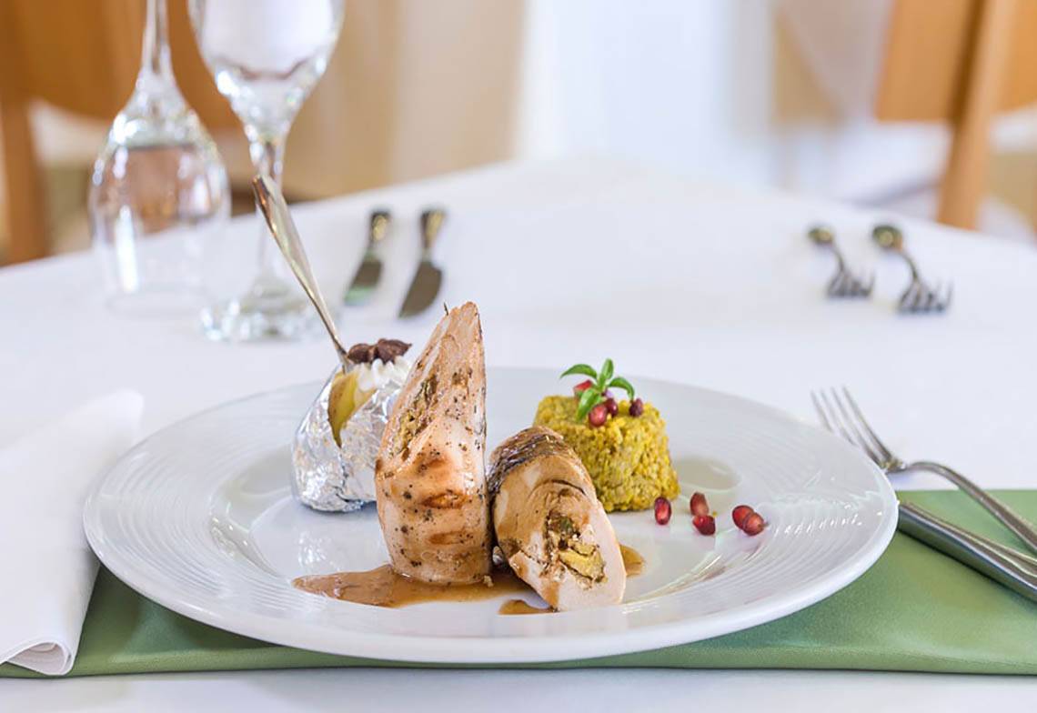 Ein gegrilltes Geflügelgericht auf einem weißen Teller im Cretan Dream Resort & Spa.