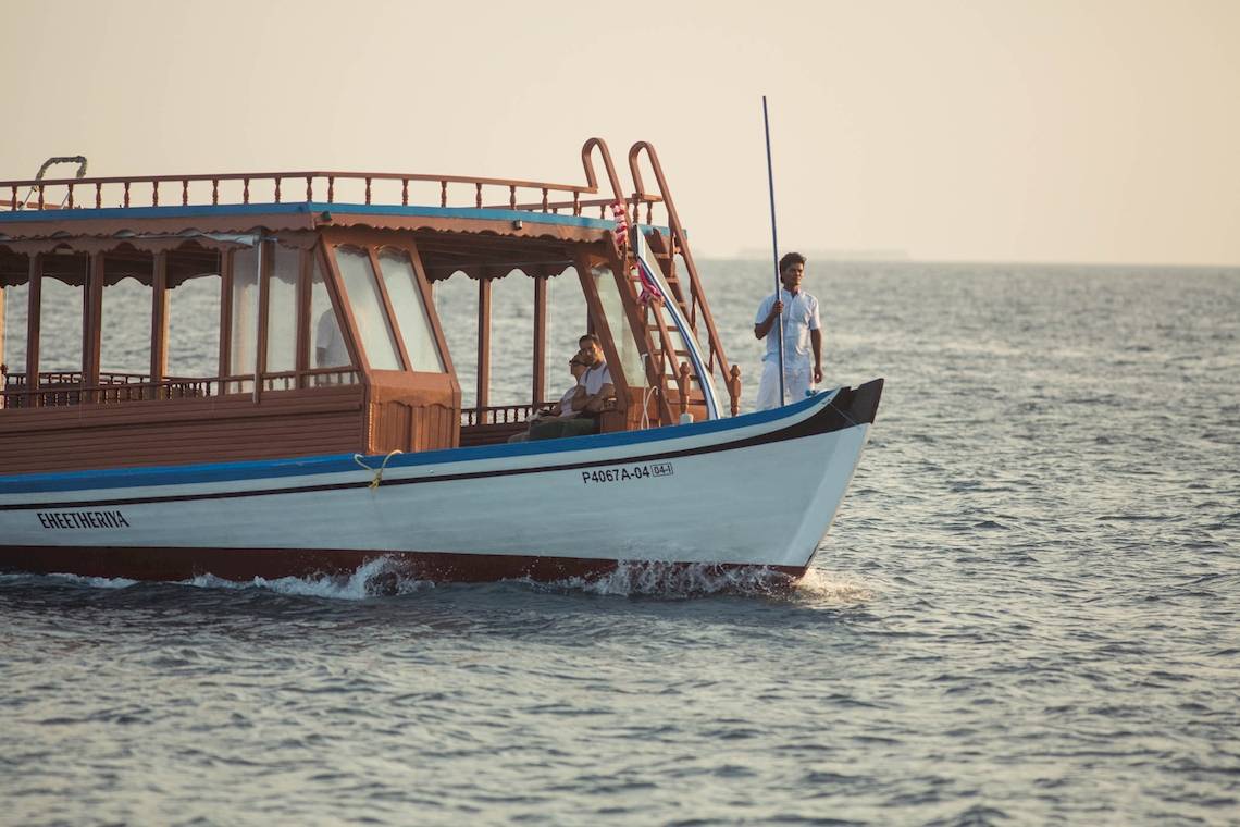 Ein Boot mit Passagieren und Kapitän im Meer während des Sonnenuntergangs