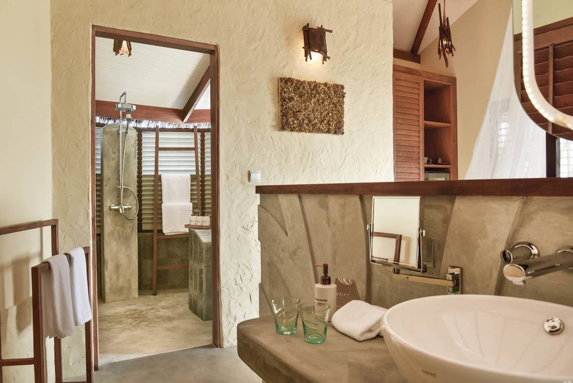 Badezimmer im Drift Thelu Veliga Retreat mit Dusche, Waschbecken und Handtüchern.