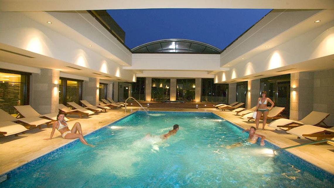 Einige Gäste entspannen und schwimmen im beheizten Innenpool des D'Andrea Mare Beach Hotels.