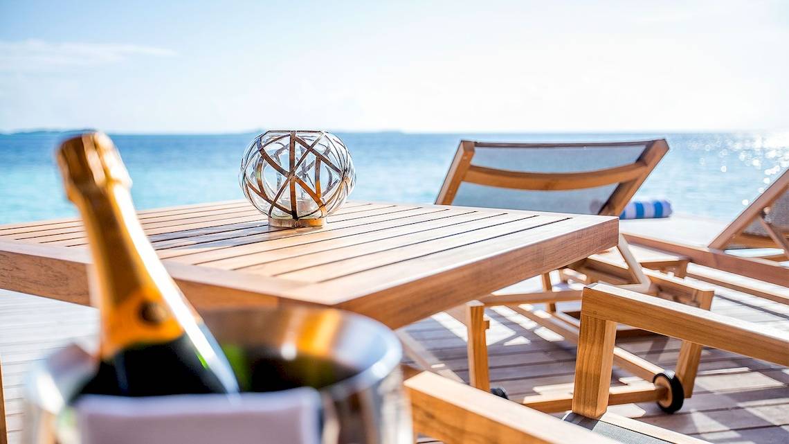 Terrasse mit Flasche Champagner am Hurawalhi Island Resort mit Blick auf das Meer