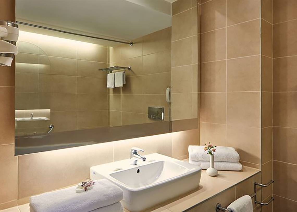 Badezimmer im Atlantica Mikri Poli Kos Hotel mit Waschbecken und Spiegel.