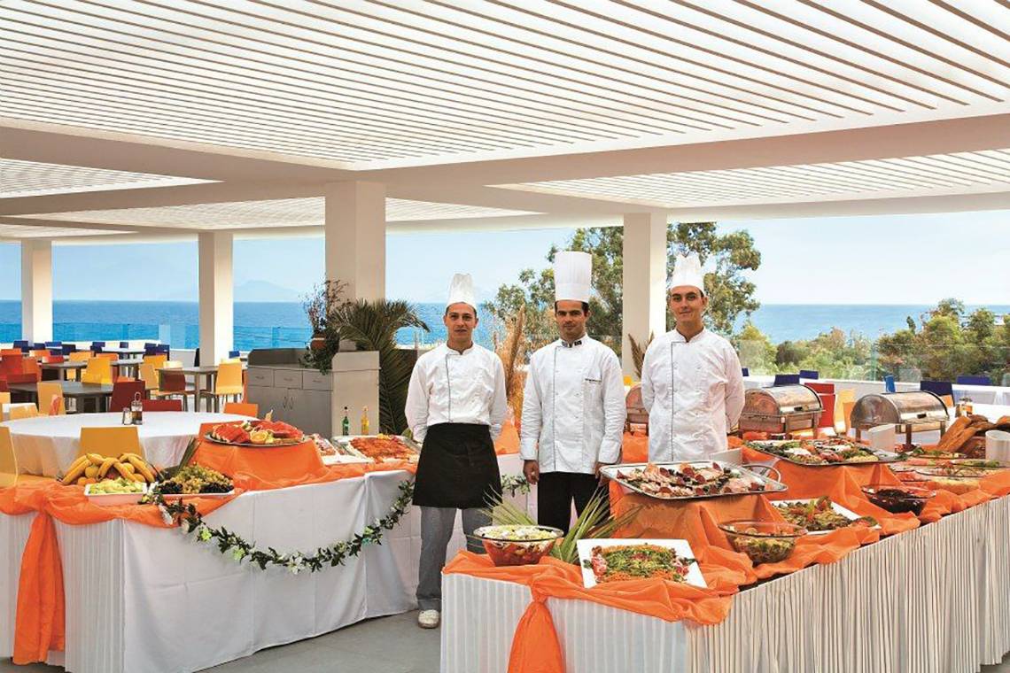 Drei Köche stehen bei einem Buffet mit Speisen im Atlantica Mikri Poli Kos.