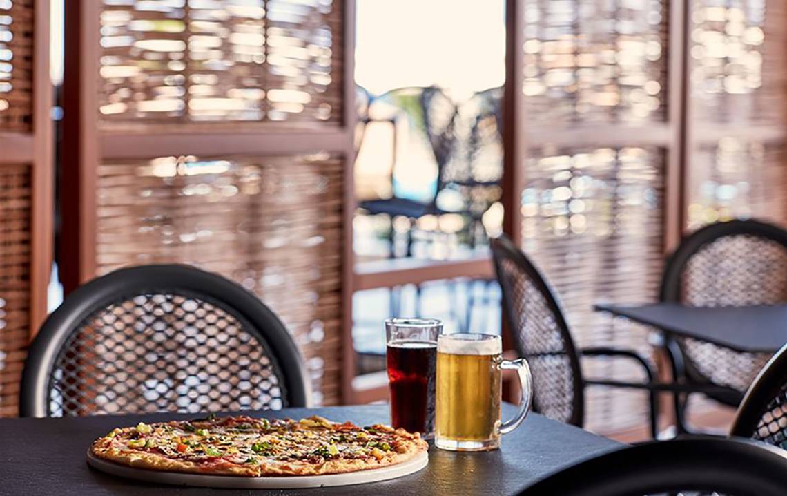 Pizza und Getränke auf einem Tisch im Restaurant des Atlantica Mikri Poli Kos.