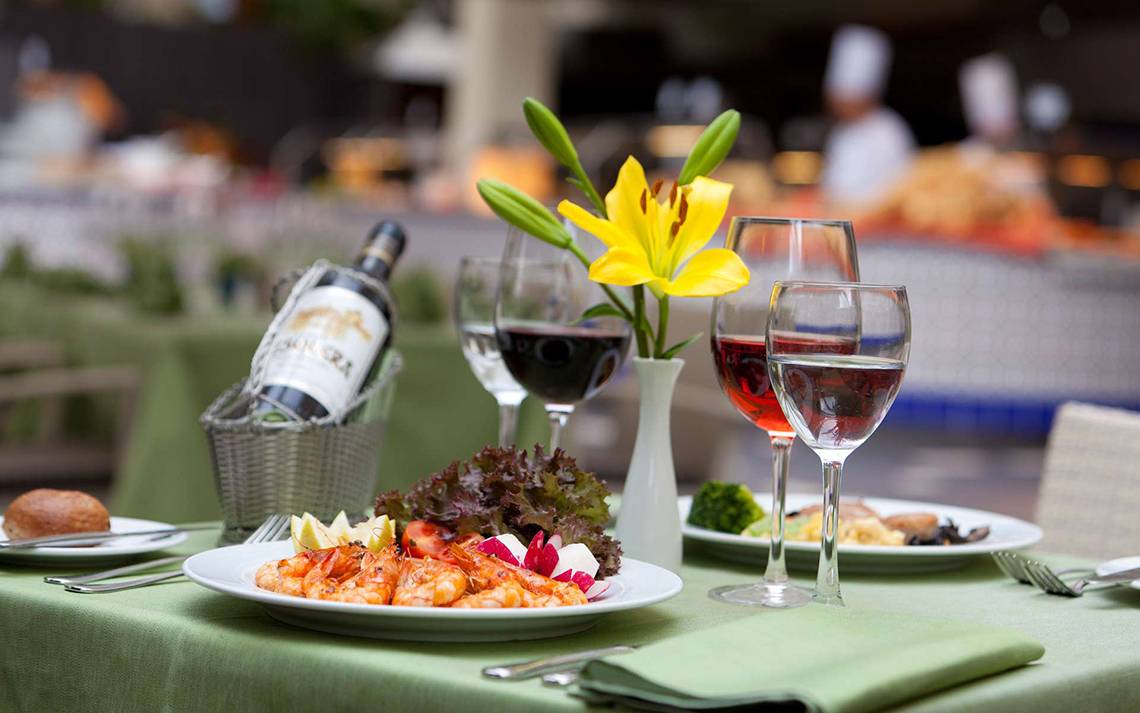 Speisetisch im Seaside Sandy Beach Hotel mit Garnelen, Wein und Salat.