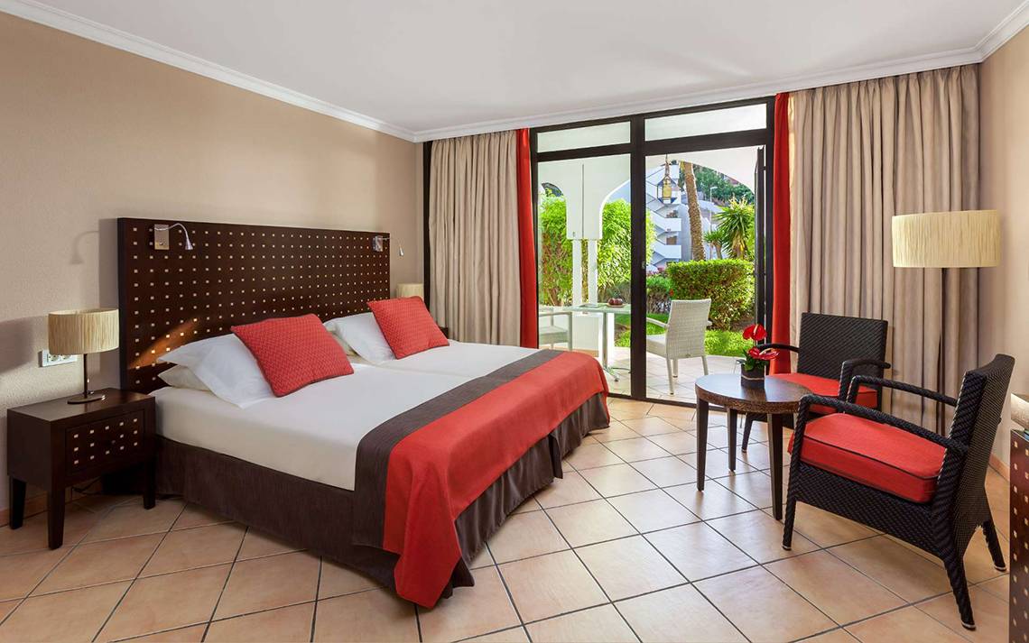 Doppelzimmer im Seaside Sandy Beach Hotel mit zwei Betten, Balkon und Sitzbereich.