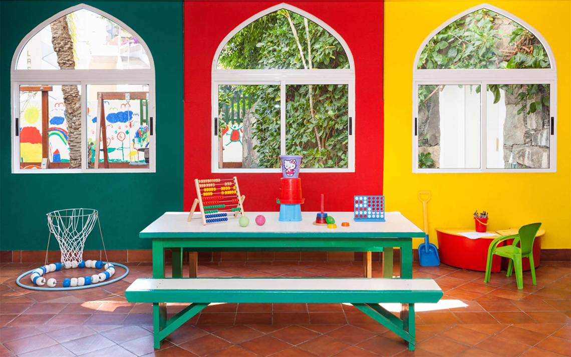 Kinderzimmer im Seaside Sandy Beach Hotel mit bunten Wänden, bunten Spielsachen und einem Tisch.