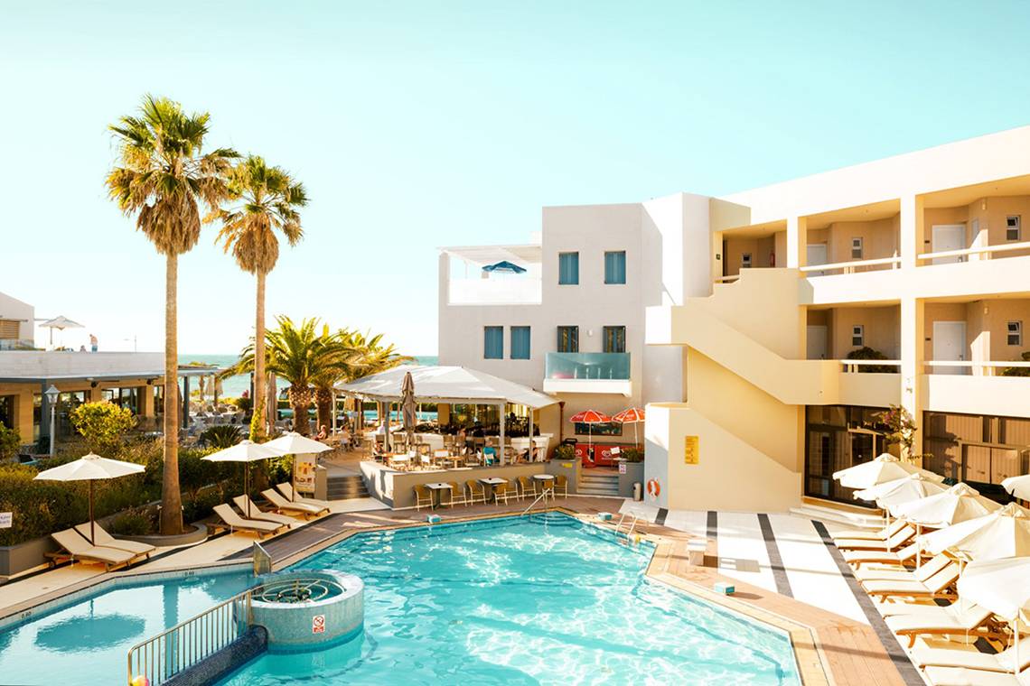 Außenpool am Strand im Pearle Beach Resort & Spa mit Sonnenliegen und Sonnenschirmen.