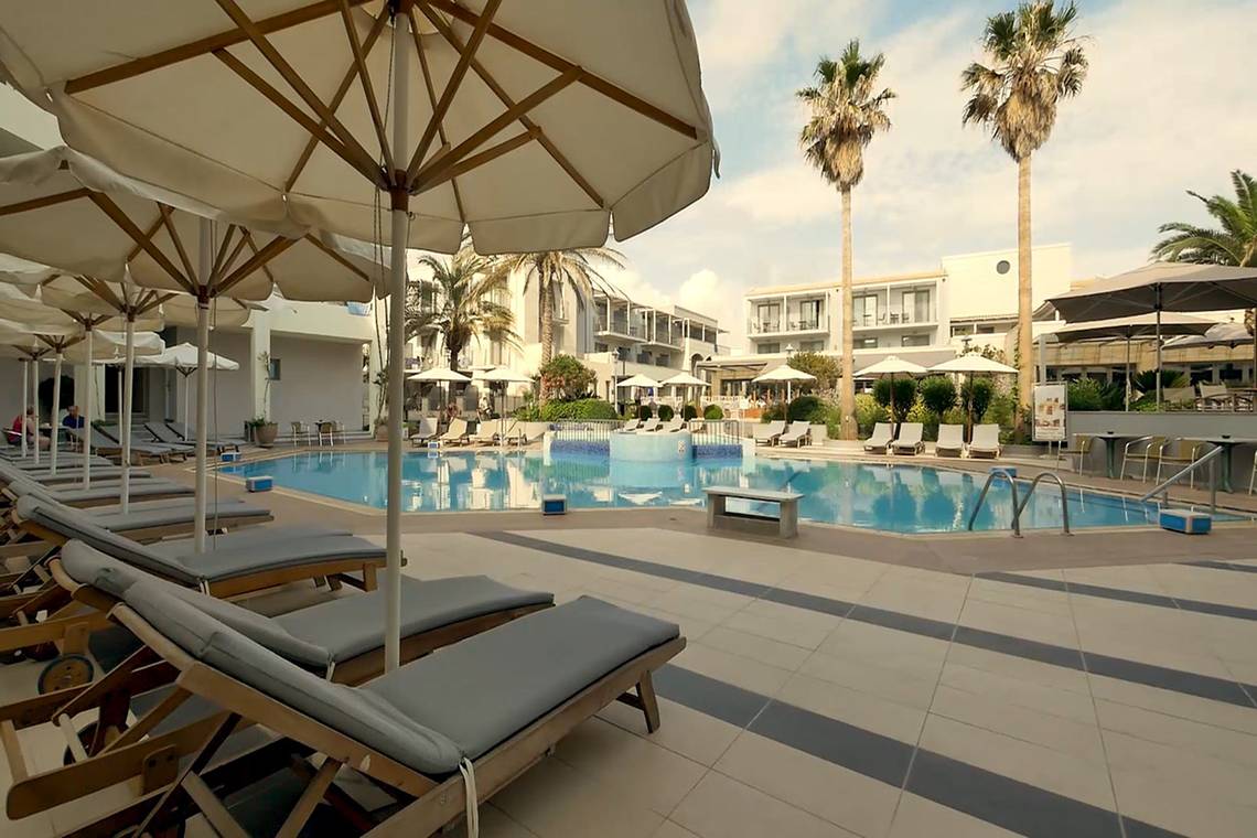 Poolbereich im Pearle Beach Resort & Spa mit Sonnenliegen und Sonnenschirmen