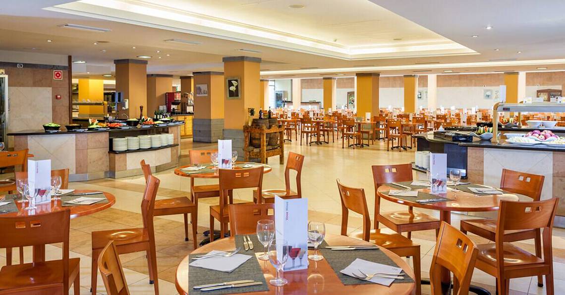 Innenansicht des Restaurants im Sol Tenerife Hotel mit runden Tischen und Stühlen.