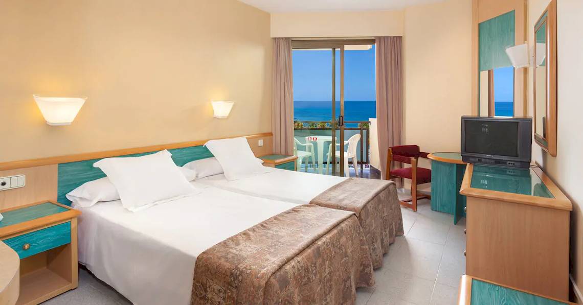 Doppelzimmer im Sol Tenerife Hotel mit Meerblick, zwei Betten, Balkon und Fernseher.