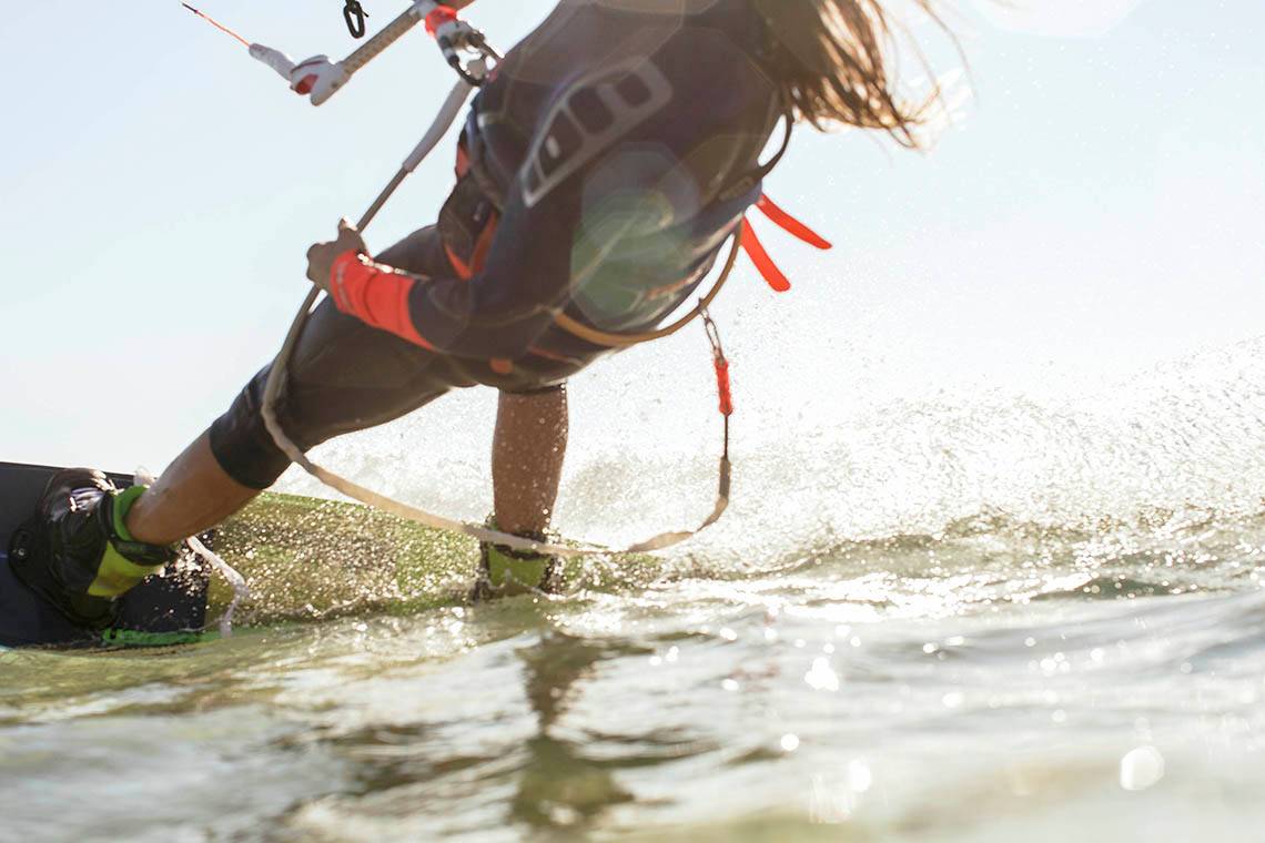 Kitesurfer im Soma Bay, der das Wasser befährt und einen Wasserski hält.