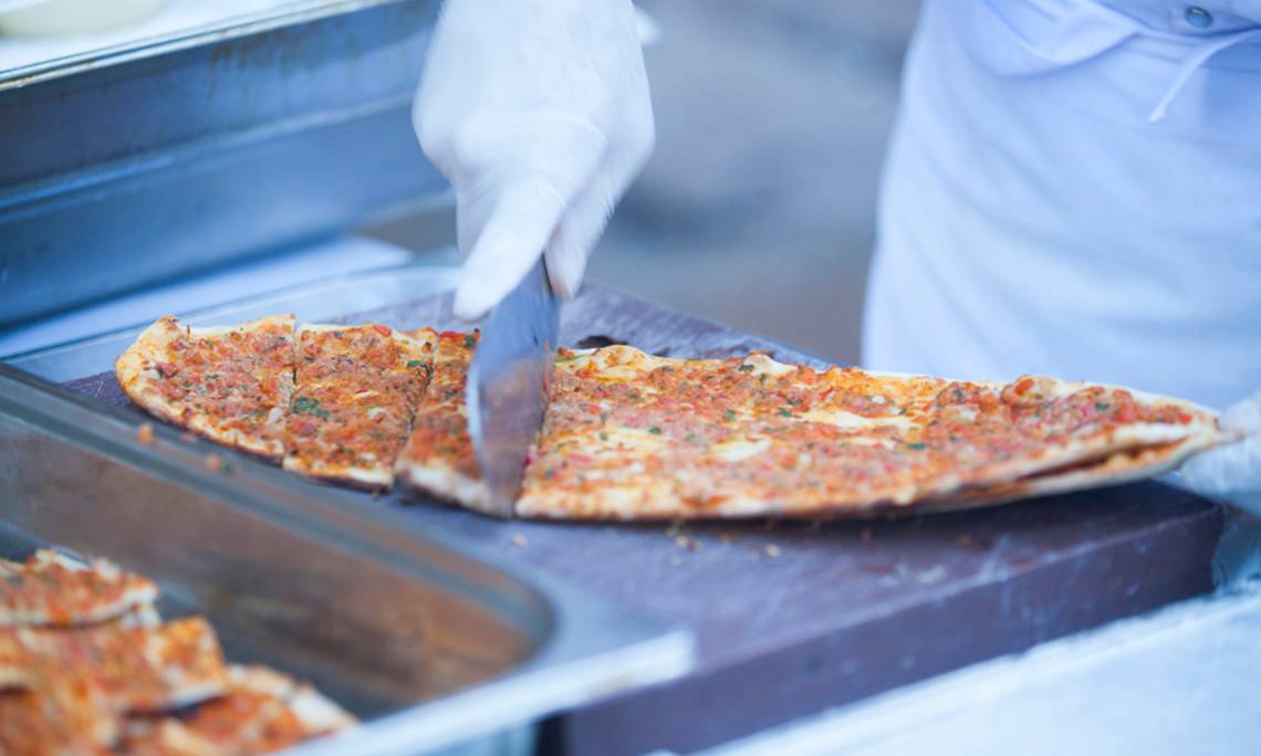 Eine Person schneidet eine Pizza im Washington Resort Hotel & SPA.