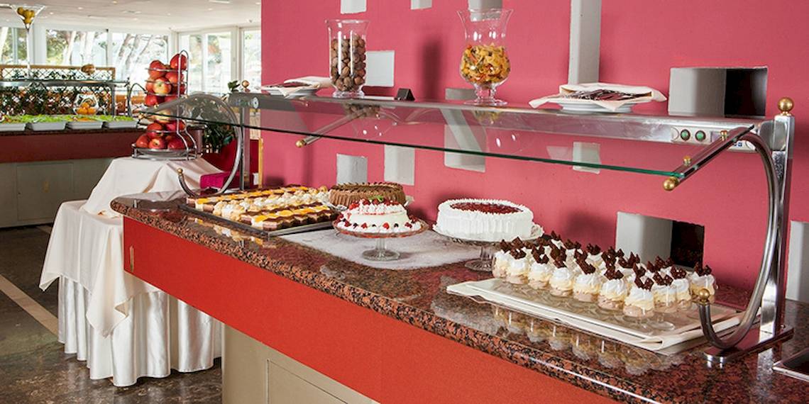 Buffet-Tisch im Zora Hotel mit verschiedenen Kuchen und Desserts.