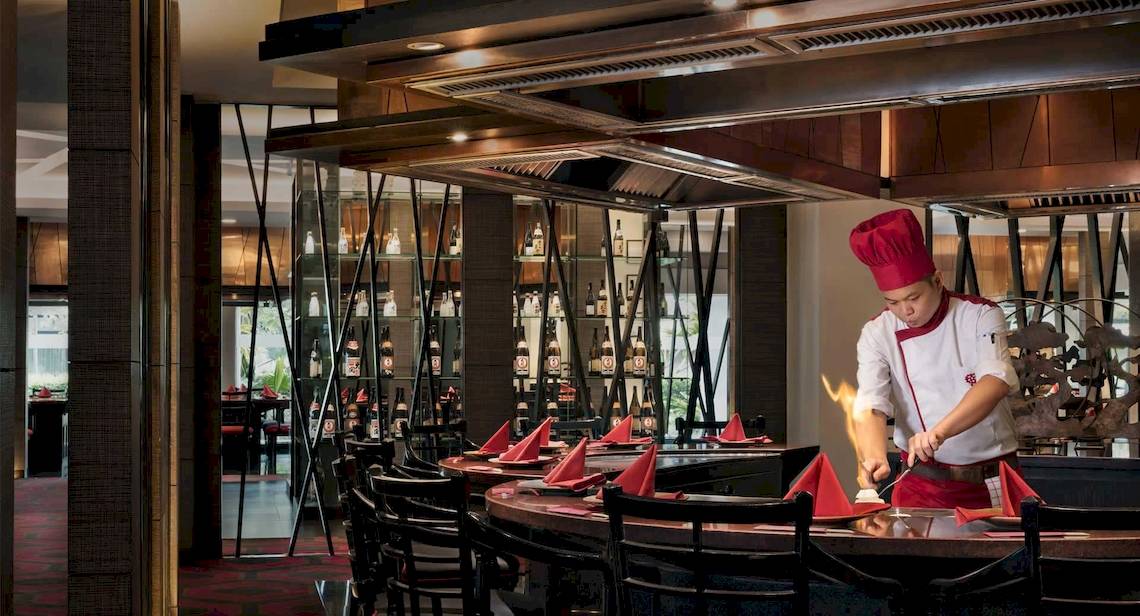 Restaurant-Interieur im Anantara Riverside Bangkok Resort mit Koch, der Essen brät