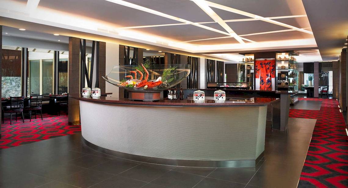Lobby des Anantara Riverside Bangkok Resorts mit moderner Einrichtung und rotem Teppich.