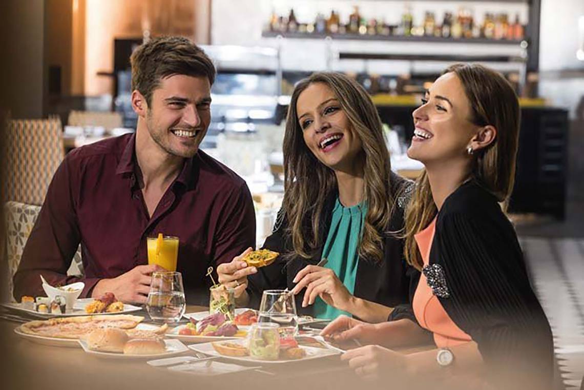 Gruppe von Männern und Frauen essen im Mövenpick Hotel Jumeirah Beach