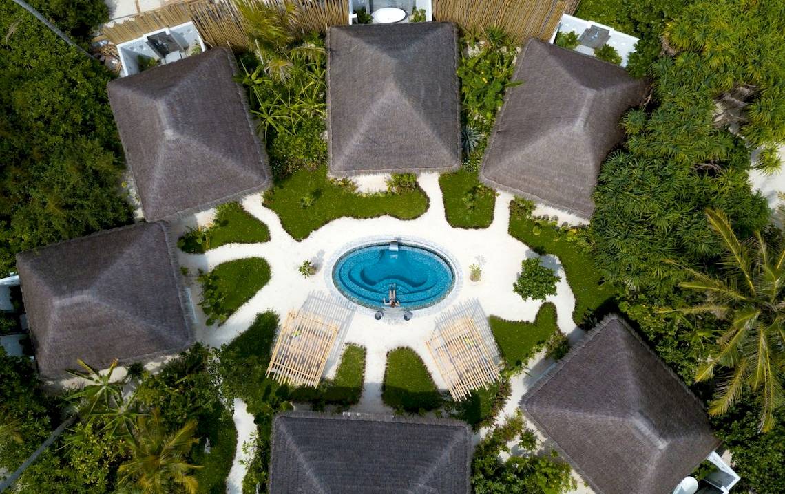 Luftaufnahme des Fushifaru Maldives Hotels mit Swimmingpool und Bungalows