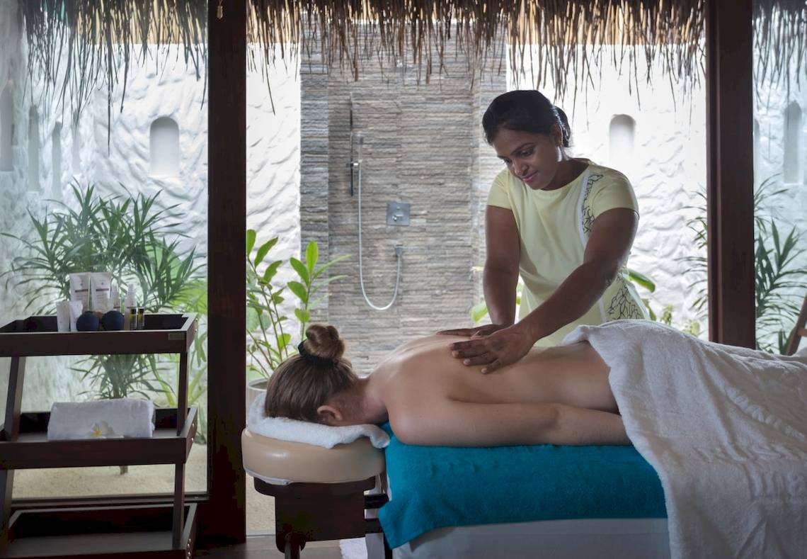 Frau erhält Massage im Fushifaru Maldives Hotel