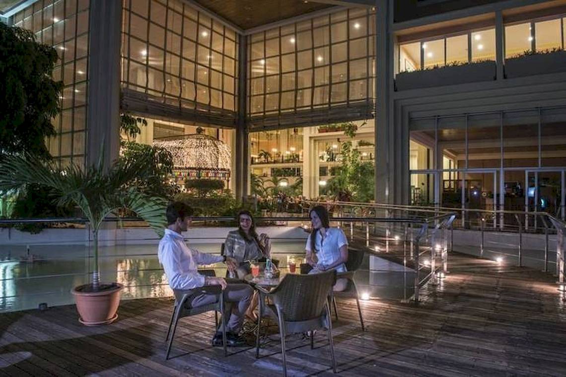 Drei Personen sitzen auf der Terrasse des Blau Varadero Hotels und genießen ein Abendessen.