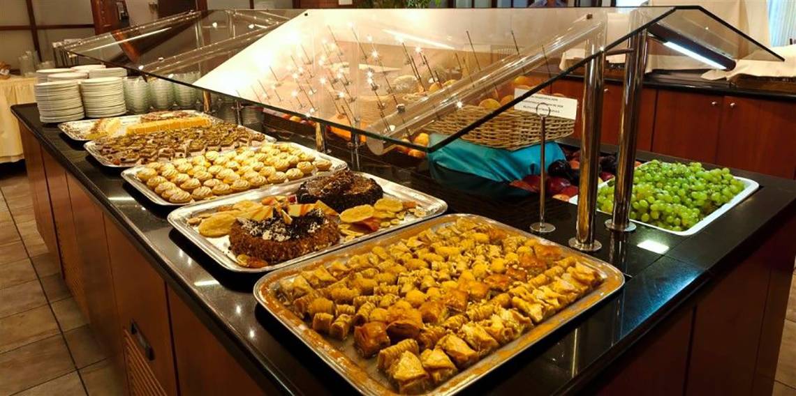 Buffet im Atlantica Marmari Beach Hotel mit verschiedenen Desserts und Früchten.