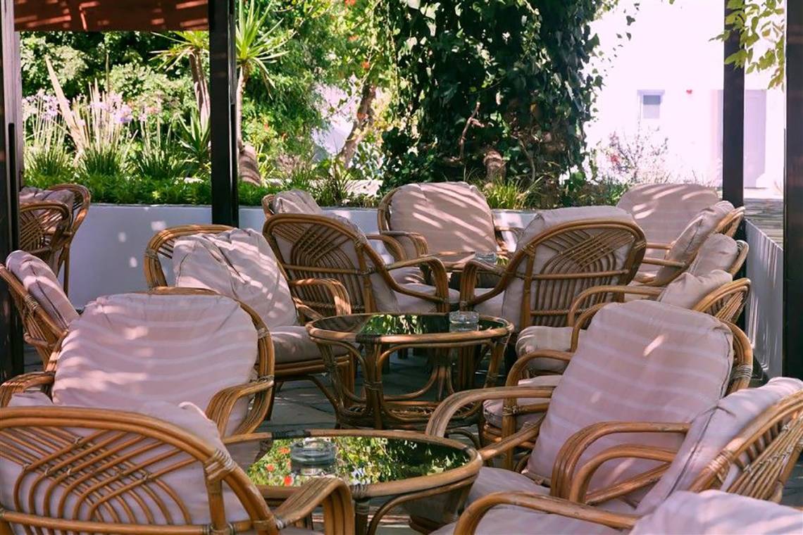 Terrasse des Atlantica Marmari Beach Hotels mit Rattanmöbeln und Kissen