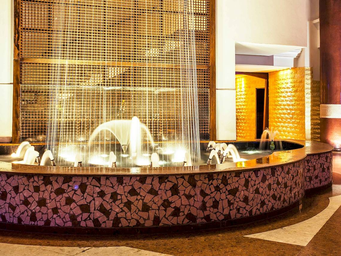 Eingangsbereich des Atlas Amadil Beach Hotels mit einem zentralen Wasserbrunnen.