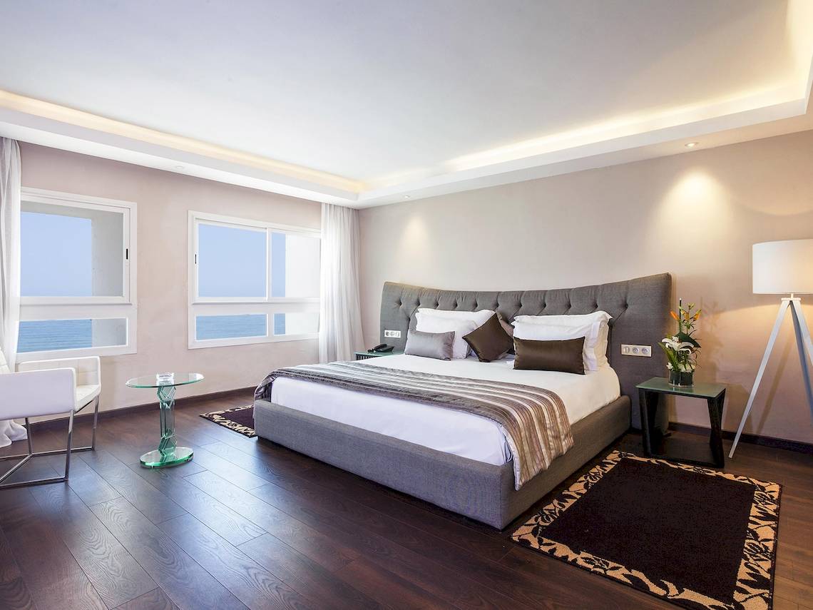 Schlafzimmer im Atlas Amadil Beach Hotel mit Meerblick, Bett, Nachttischen und Dekor.
