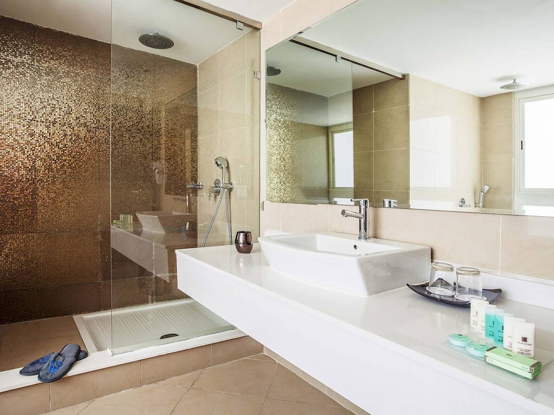 Badezimmer im Atlas Amadil Beach Hotel mit einer großen Glasdusche und einem Waschbecken.