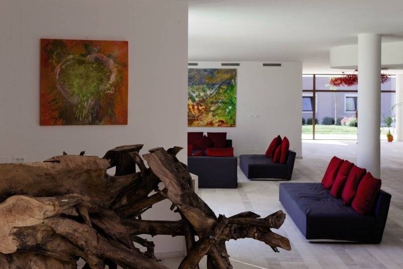 Innenbereich des Baglioni Resort Sardinia mit Möbeln und Kunstwerken.