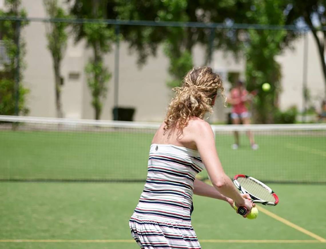 Tennisspielerin im Atlantica Holiday Village Kos, die einen Ball schlägt.