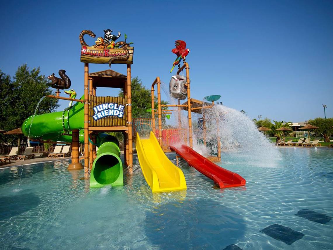 Wasserpark im Atlantica Holiday Village Kos mit drei bunten Rutschen und einem Wasserfall.