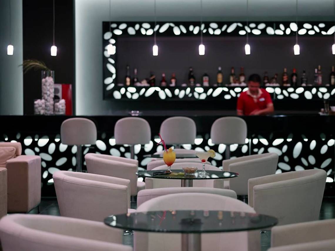 Hotelbar im Atlantica Holiday Village Kos mit Cocktails und Barkeeper im Hintergrund.