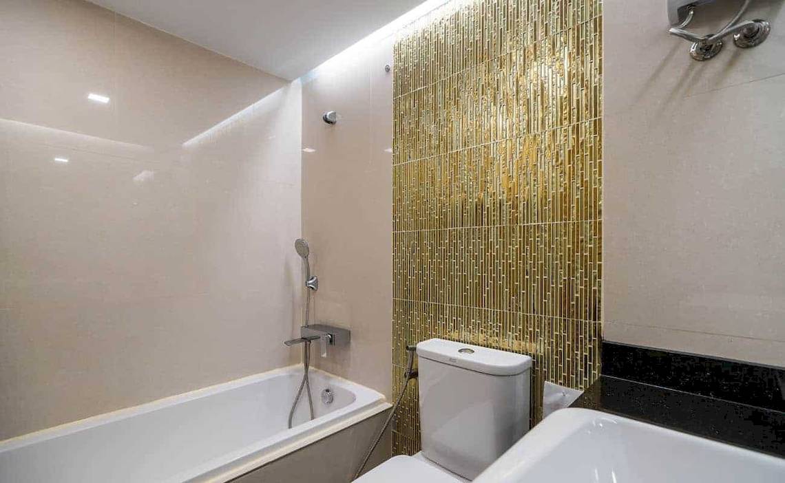 Badezimmer des Chaba Samui Resort mit Badewanne, Toilette und Waschbecken.