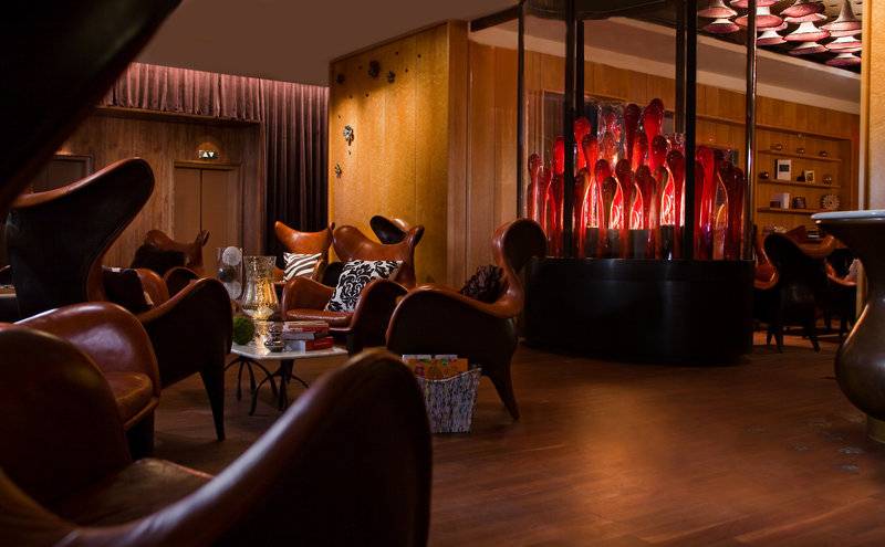 Loungebereich des New York-New York Hotel & Casino mit Ledersesseln und einer roten Skulptur.