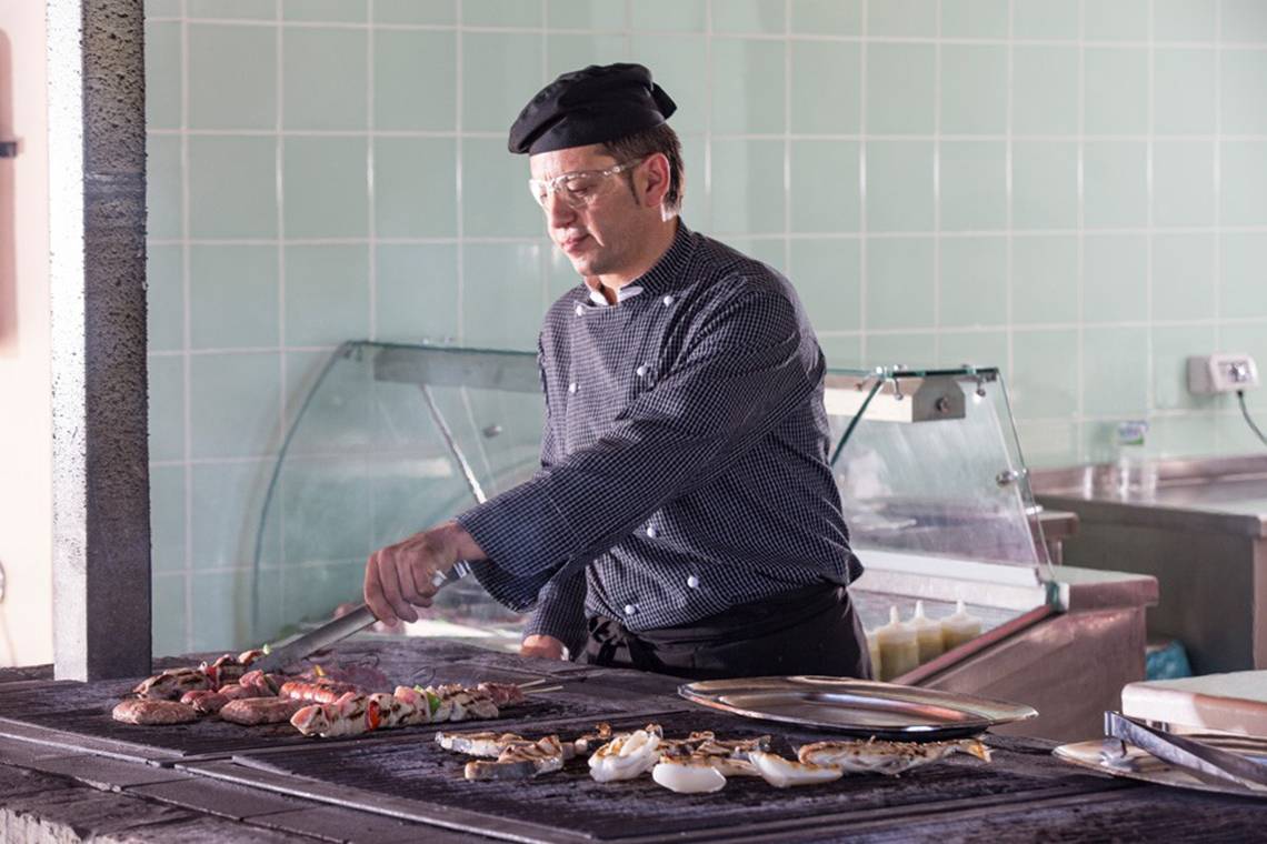 Koch grillt auf einem Grill im Kontokali Bay Resort & Spa Hotel.