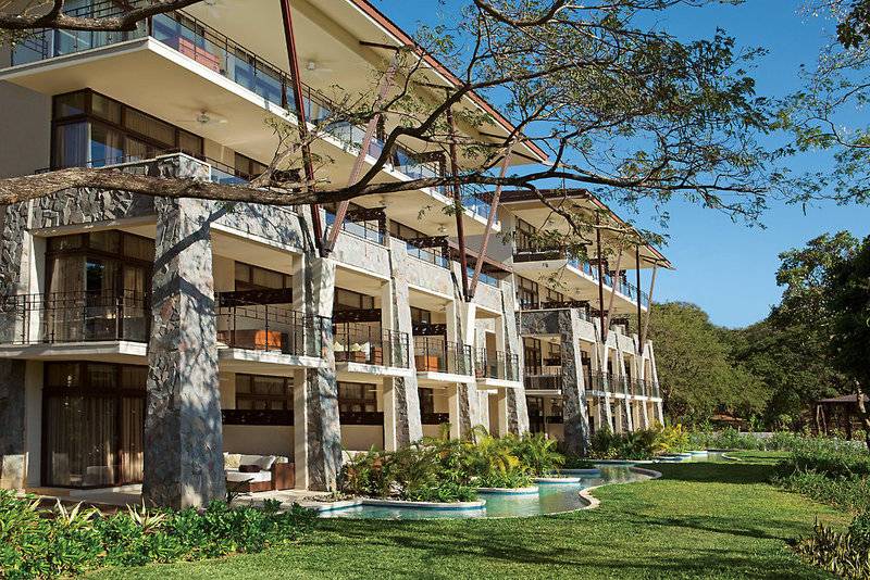Außenansicht des Dreams Las Mareas Costa Rica Hotels mit mehreren Stockwerken, Balkonen und einem Swimmingpool.