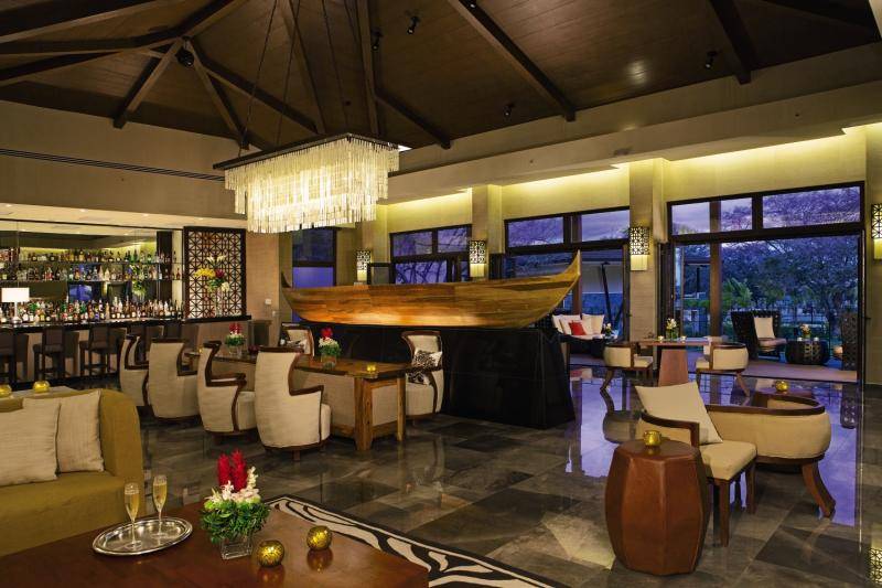 Lobby des Dreams Las Mareas Costa Rica Hotels mit Bar, Tischen und Stühlen.
